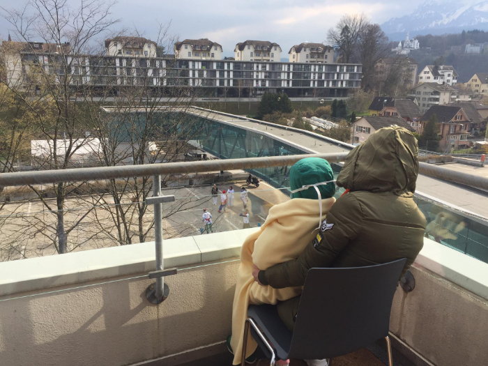 Un petit patient et son papa observent le numéro des docteurs Rêves depuis le balcon de l'hôpital de Lucerne.