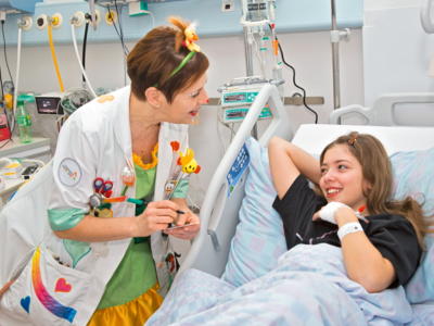 Melanie erhält Besuch von Dr. Tiramisù und freut sich über die willkommene Ablenkung während ihrem Aufenthalt im Regionalen Spital Bellinzona. Foto: Stefano Spinelli