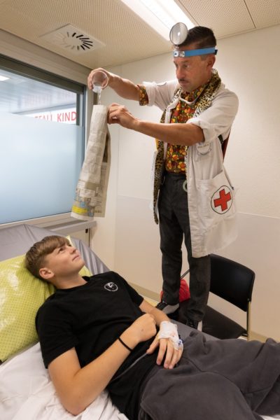 Dr. Leberwurst fascine un adolescent avec un tour de magie dans la clinique pédiatrique de l’Hôpital Universitaire de l’Île à Berne.
